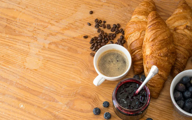 Roman breakfast spread of fresh cornetti, espresso, seasonal fruit and jam at Hotel Colle Oppio — the food culture that draws guests to Roman cooking classes.