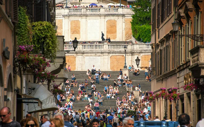 Evening light on Piazza della Madonna dei Monti — the 16th-century Della Porta fountain and the cobblestoned square that anchors Rione Monti, three minutes from Hotel Colle Oppio.
