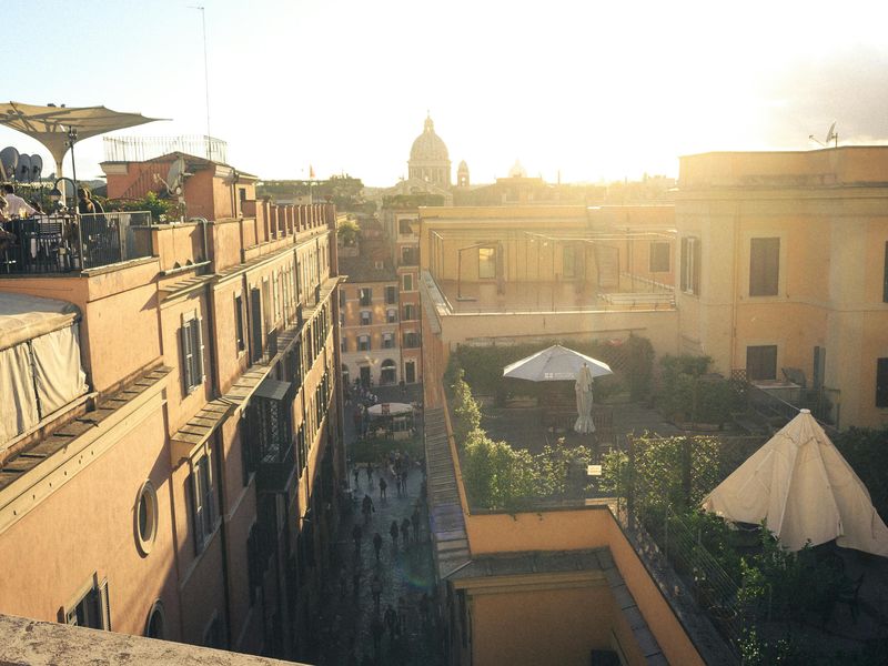 Rooftop terrace view over Roman rooftops at golden hour from Hotel Colle Oppio